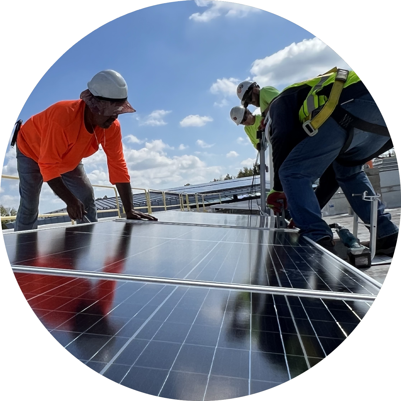 HEART energy & resource circle photo of 2 workers handling a solar panel on a roof