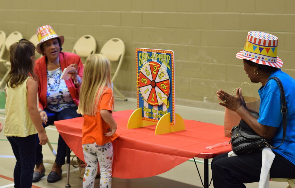 Senior Adults playing a carnival game with children